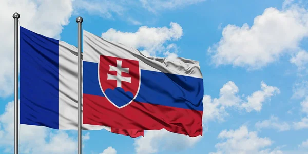 法国和斯洛伐克国旗在风中飘扬，白云蓝天相逢。外交概念、国际关系. — 图库照片