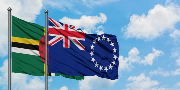 Dominika ve Cook Adaları bayrağı birlikte beyaz bulutlu mavi gökyüzüne karşı rüzgarda sallayarak. Diplomasi kavramı, uluslararası ilişkiler. — Stok fotoğraf