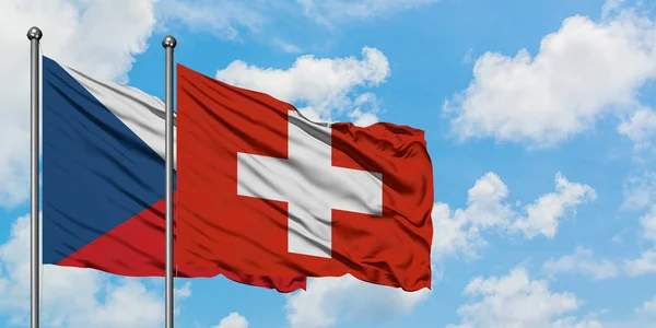 Vlajka České republiky a Švýcarska se ve větru vlnící na bíle zatažené modré obloze. Diplomacie, mezinárodní vztahy. — Stock fotografie