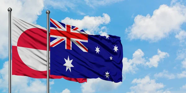 Bandera de Groenlandia y Australia ondeando en el viento contra el cielo azul nublado blanco juntos. Concepto diplomático, relaciones internacionales . —  Fotos de Stock