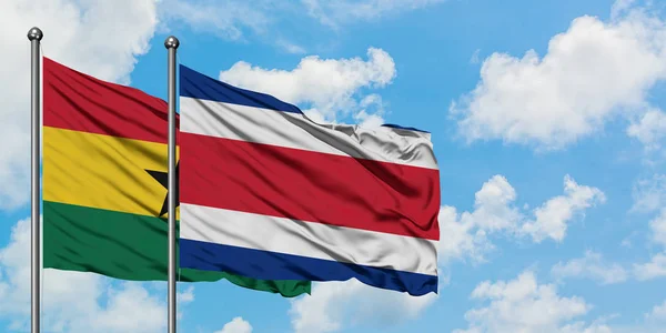 Гана і Коста-Ріка прапор розмахуючи в вітру проти білого хмарного синього неба разом. Концепція дипломатії, міжнародні відносини. — стокове фото