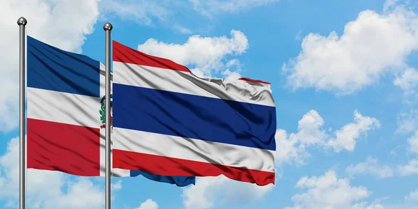 República Dominicana e Tailândia bandeira acenando no vento contra o céu azul nublado branco juntos. Conceito de diplomacia, relações internacionais . — Fotografia de Stock