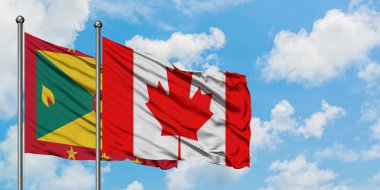 Grenada ve Kanada bayrağı birlikte beyaz bulutlu mavi gökyüzüne karşı rüzgarda sallayarak. Diplomasi kavramı, uluslararası ilişkiler.