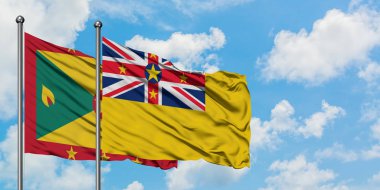 Grenada ve Niue bayrağı birlikte beyaz bulutlu mavi gökyüzüne karşı rüzgarda sallayarak. Diplomasi kavramı, uluslararası ilişkiler.