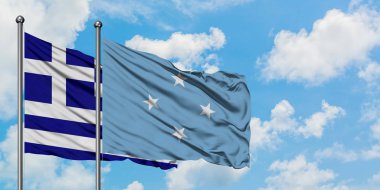 Yunanistan ve Mikronezya bayrağı birlikte beyaz bulutlu mavi gökyüzüne karşı rüzgarda sallayarak. Diplomasi kavramı, uluslararası ilişkiler.