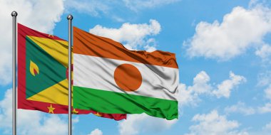 Grenada ve Nijer bayrağı birlikte beyaz bulutlu mavi gökyüzüne karşı rüzgarda sallayarak. Diplomasi kavramı, uluslararası ilişkiler.