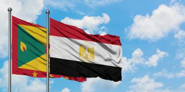 Grenada ve Mısır bayrağı birlikte beyaz bulutlu mavi gökyüzüne karşı rüzgarda sallayarak. Diplomasi kavramı, uluslararası ilişkiler.