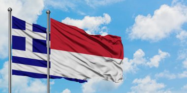 Yunanistan ve Monako bayrağı birlikte beyaz bulutlu mavi gökyüzüne karşı rüzgarsal sallayarak. Diplomasi kavramı, uluslararası ilişkiler.