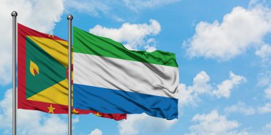 Grenada ve Sierra Leone bayrağı birlikte beyaz bulutlu mavi gökyüzüne karşı rüzgarda sallayarak. Diplomasi kavramı, uluslararası ilişkiler.