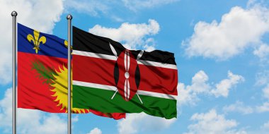 Guadeloupe ve Kenya bayrağı birlikte beyaz bulutlu mavi gökyüzüne karşı rüzgarda sallayarak. Diplomasi kavramı, uluslararası ilişkiler.