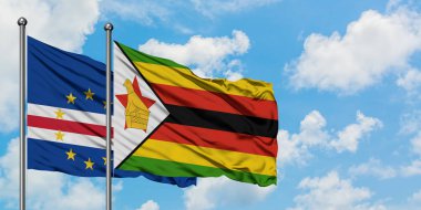 Cape Verde ve Zimbabve bayrağı birlikte beyaz bulutlu mavi gökyüzüne karşı rüzgarda sallayarak. Diplomasi kavramı, uluslararası ilişkiler.