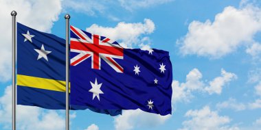 Curacao ve Avustralya bayrağı birlikte beyaz bulutlu mavi gökyüzüne karşı rüzgarda sallayarak. Diplomasi kavramı, uluslararası ilişkiler.