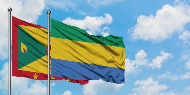Grenada ve Gabon bayrağı birlikte beyaz bulutlu mavi gökyüzüne karşı rüzgarda sallayarak. Diplomasi kavramı, uluslararası ilişkiler.