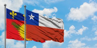 Guadeloupe ve Şili bayrağı birlikte beyaz bulutlu mavi gökyüzüne karşı rüzgarda sallayarak. Diplomasi kavramı, uluslararası ilişkiler.