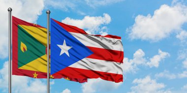 Grenada ve Porto Riko bayrağı birlikte beyaz bulutlu mavi gökyüzüne karşı rüzgarda sallayarak. Diplomasi kavramı, uluslararası ilişkiler.