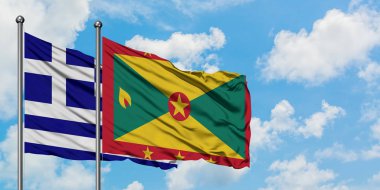 Yunanistan ve Grenada bayrağı birlikte beyaz bulutlu mavi gökyüzüne karşı rüzgarda sallayarak. Diplomasi kavramı, uluslararası ilişkiler.