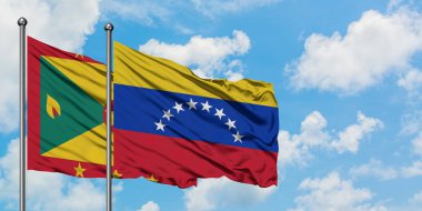 Grenada ve Venezuela bayrağı birlikte beyaz bulutlu mavi gökyüzüne karşı rüzgarda sallayarak. Diplomasi kavramı, uluslararası ilişkiler.