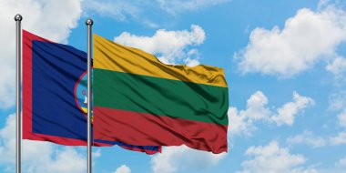 Guam ve Litvanya bayrağı birlikte beyaz bulutlu mavi gökyüzüne karşı rüzgarda sallayarak. Diplomasi kavramı, uluslararası ilişkiler.