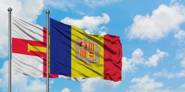 Guernsey ve Andorra bayrağı birlikte beyaz bulutlu mavi gökyüzüne karşı rüzgarda sallayarak. Diplomasi kavramı, uluslararası ilişkiler.