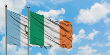 Guatemala ve İrlanda bayrağı birlikte beyaz bulutlu mavi gökyüzüne karşı rüzgarda sallayarak. Diplomasi kavramı, uluslararası ilişkiler.