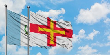 Guatemala ve Guernseyguernsey, Guernsey bayrağı, kanal adaları, birlikte beyaz bulutlu mavi gökyüzüne karşı rüzgarda sallayarak gerilla bayrağı. Diplomasi kavramı, uluslararası ilişkiler.