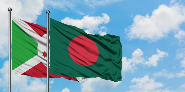 Bandera de Burundi y Bangladesh ondeando en el viento contra el cielo azul nublado blanco juntos. Concepto diplomático, relaciones internacionales . — Foto de Stock