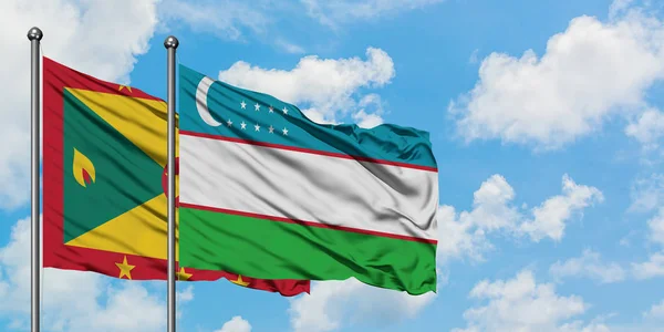 Grenada e la bandiera dell'Uzbekistan sventolano insieme nel vento contro il bianco cielo blu nuvoloso. Concetto di diplomazia, relazioni internazionali . — Foto Stock