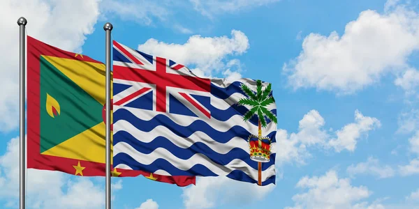 Bandera de Granada y del Territorio Británico del Océano Índico ondeando en el viento contra el cielo azul nublado blanco juntos. Concepto diplomático, relaciones internacionales . — Foto de Stock