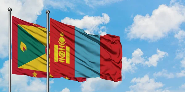 Bandera de Granada y Mongolia ondeando en el viento contra el cielo azul nublado blanco juntos. Concepto diplomático, relaciones internacionales . — Foto de Stock