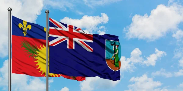 Guadalupe y la bandera de Montserrat ondeando en el viento contra el cielo azul nublado blanco juntos. Concepto diplomático, relaciones internacionales . — Foto de Stock