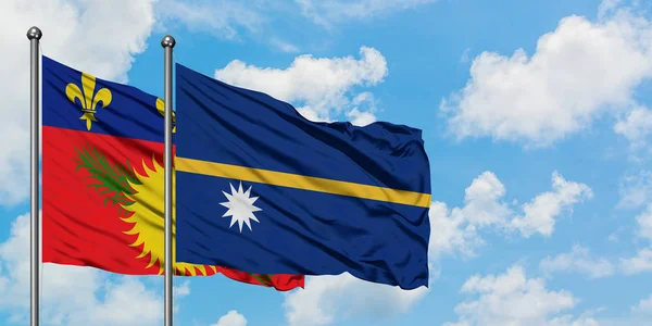 Guadalupe y la bandera de Nauru ondeando en el viento contra el cielo azul nublado blanco juntos. Concepto diplomático, relaciones internacionales . — Foto de Stock