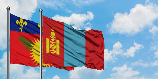 Guadalupe y Mongolia bandera ondeando en el viento contra el cielo azul nublado blanco juntos. Concepto diplomático, relaciones internacionales . — Foto de Stock