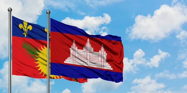 Bandera de Guadalupe y Camboya ondeando en el viento contra el cielo azul nublado blanco juntos. Concepto diplomático, relaciones internacionales . — Foto de Stock