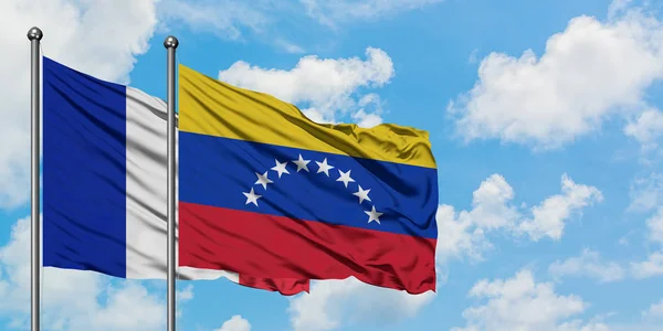 Franciaország és Venezuela zászló integetett a szél ellen, fehér felhős kék ég együtt. Diplomáciai koncepció, nemzetközi kapcsolatok. — Stock Fotó