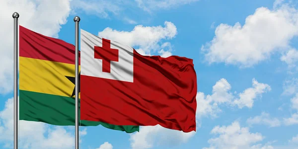 Bandera de Ghana y Tonga ondeando en el viento contra el cielo azul nublado blanco juntos. Concepto diplomático, relaciones internacionales . — Foto de Stock