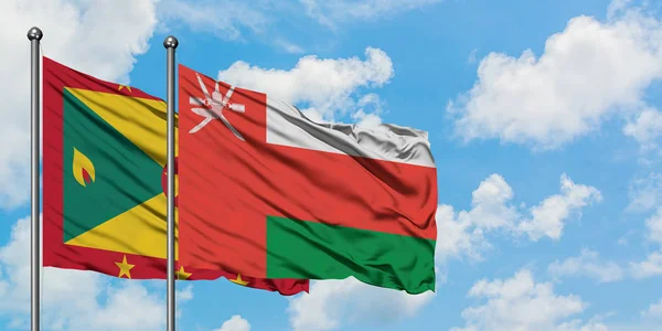 Granate und omanische Flagge wehten gemeinsam im Wind gegen den wolkenverhangenen blauen Himmel. Diplomatie-Konzept, internationale Beziehungen. — Stockfoto