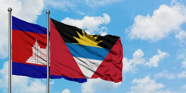 Camboya y Antigua y Barbuda ondeando en el viento contra el cielo azul nublado blanco juntos. Concepto diplomático, relaciones internacionales . — Foto de Stock