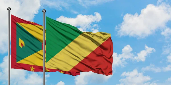 Bandera de Granada y República del Congo ondeando en el viento contra el cielo azul nublado blanco juntos. Concepto diplomático, relaciones internacionales . — Foto de Stock