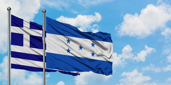 Grecia e Honduras bandiera sventolando nel vento contro bianco cielo blu nuvoloso insieme. Concetto di diplomazia, relazioni internazionali . — Foto Stock