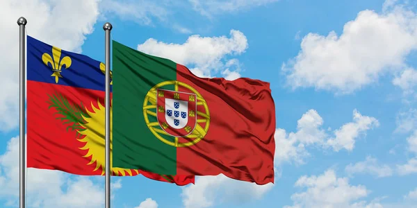 Guadeloupe och Portugal flagga vinka i vinden mot vit grumlig blå himmel tillsammans. Diplomatisk koncept, internationella relationer. — Stockfoto