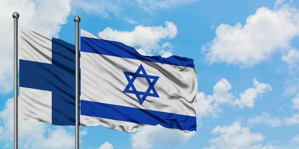 Bandera de Finlandia e Israel ondeando en el viento contra el cielo azul nublado blanco juntos. Concepto diplomático, relaciones internacionales . —  Fotos de Stock