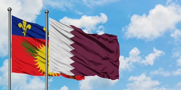 Guadalupe y Qatar bandera ondeando en el viento contra el blanco cielo azul nublado juntos. Concepto diplomático, relaciones internacionales . —  Fotos de Stock