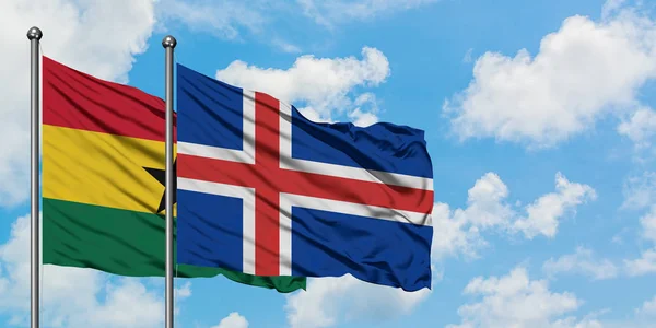 Bandera de Ghana e Islandia ondeando en el viento contra el cielo azul nublado blanco juntos. Concepto diplomático, relaciones internacionales . — Foto de Stock