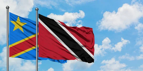 Kongo ve Trinidad ve Tobago bayrağı birlikte beyaz bulutlu mavi gökyüzüne karşı rüzgarda sallayarak. Diplomasi kavramı, uluslararası ilişkiler. — Stok fotoğraf