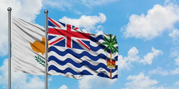 Bandera de Chipre y del Territorio Británico del Océano Índico ondeando en el viento contra el cielo azul nublado blanco juntos. Concepto diplomático, relaciones internacionales . — Foto de Stock