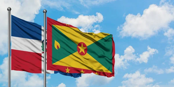 Bandera de República Dominicana y Granada ondeando en el viento contra el cielo azul nublado blanco juntos. Concepto diplomático, relaciones internacionales . — Foto de Stock