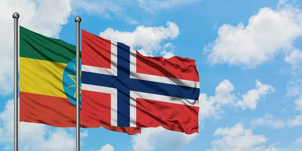 Bandera de Etiopía y Noruega ondeando en el viento contra el cielo azul nublado blanco juntos. Concepto diplomático, relaciones internacionales . — Foto de Stock