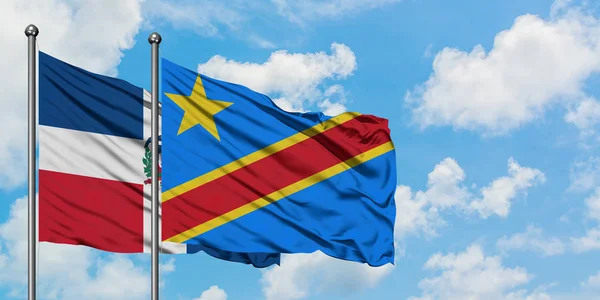 Bandera de República Dominicana y Congo ondeando en el viento contra el cielo azul nublado blanco juntos. Concepto diplomático, relaciones internacionales . — Foto de Stock