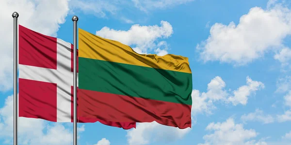 Drapeau du Danemark et de la Lituanie agitant dans le vent contre ciel bleu nuageux blanc ensemble. Concept de diplomatie, relations internationales . — Photo