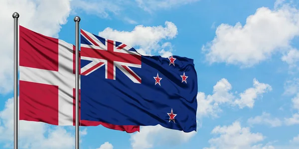 丹麦和新西兰国旗在风中飘扬，与白云蓝天相一起。外交概念、国际关系. — 图库照片